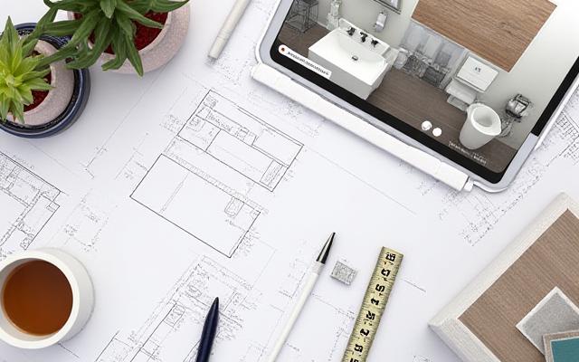 Architectural drawings and material samples on a desk, representing meticulous project management for a bathroom renovation